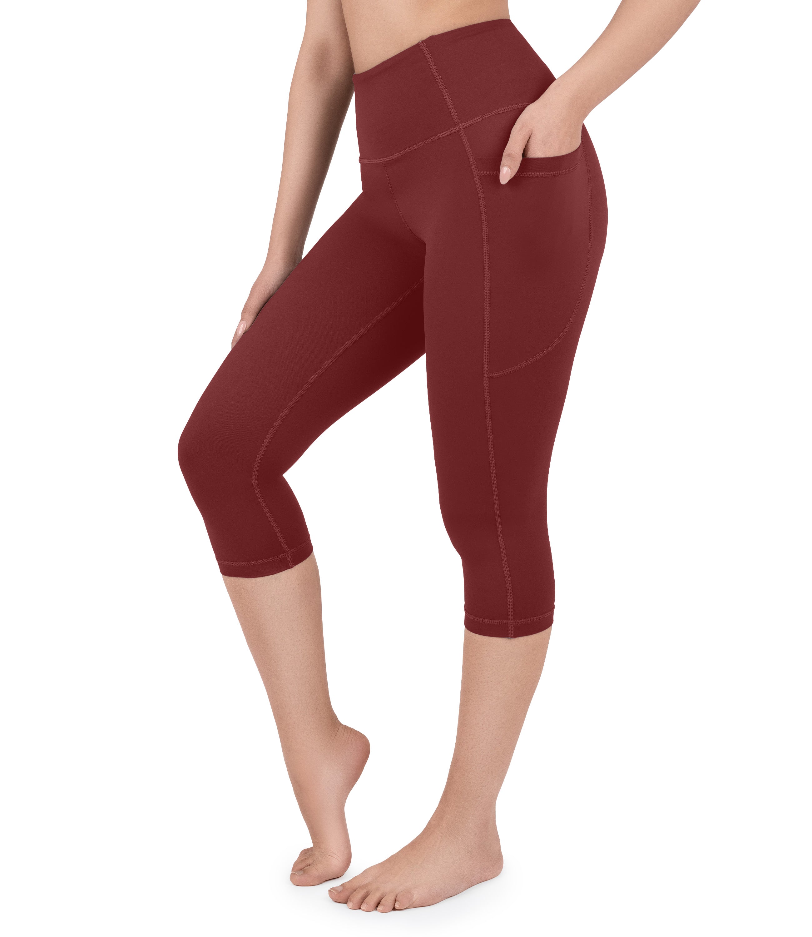 Front view of woman wearing NirLUX capri leggings with pockets in rio red