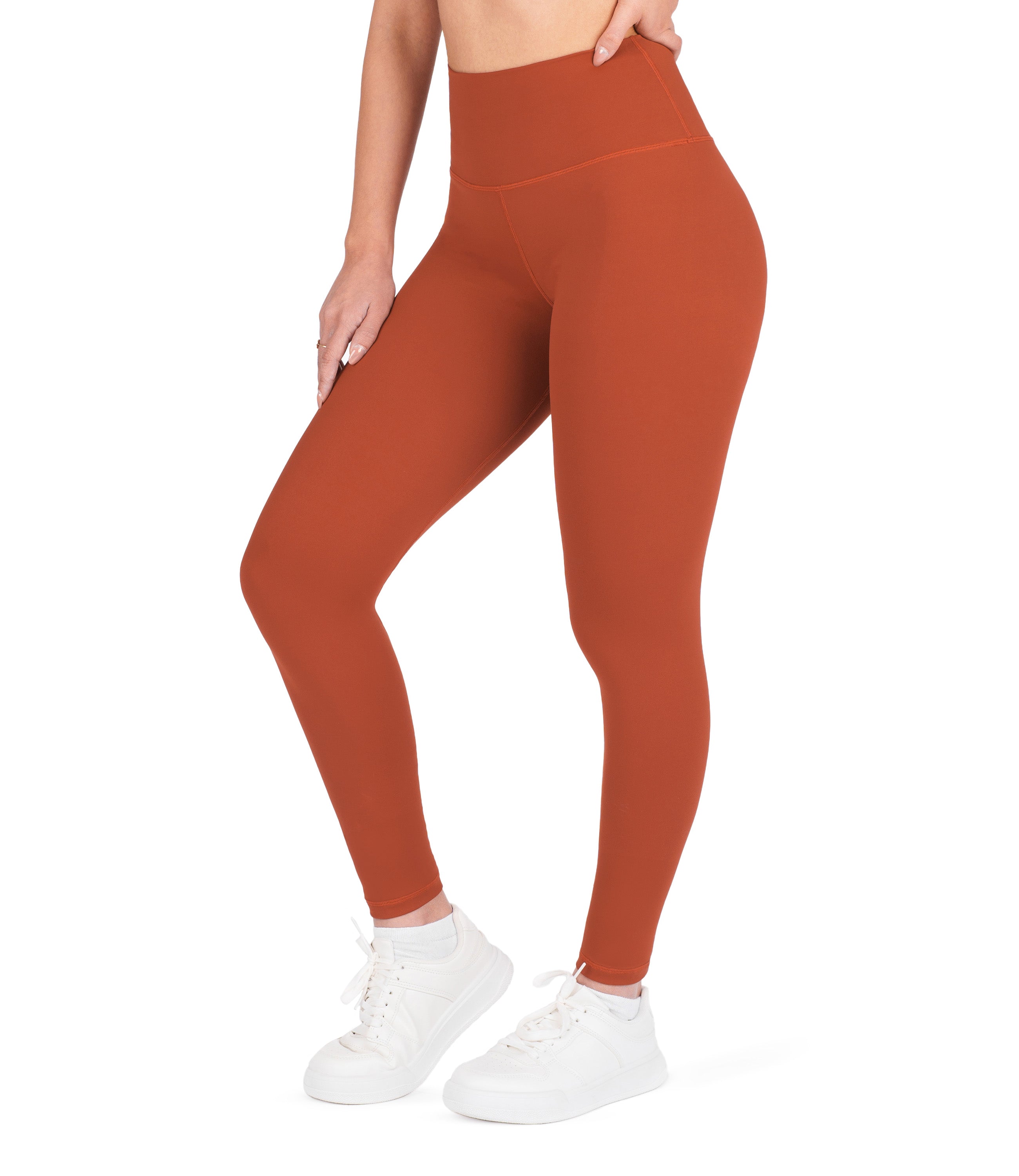 Front view of woman wearing NirLUX high waist ankle leggings in intense rust