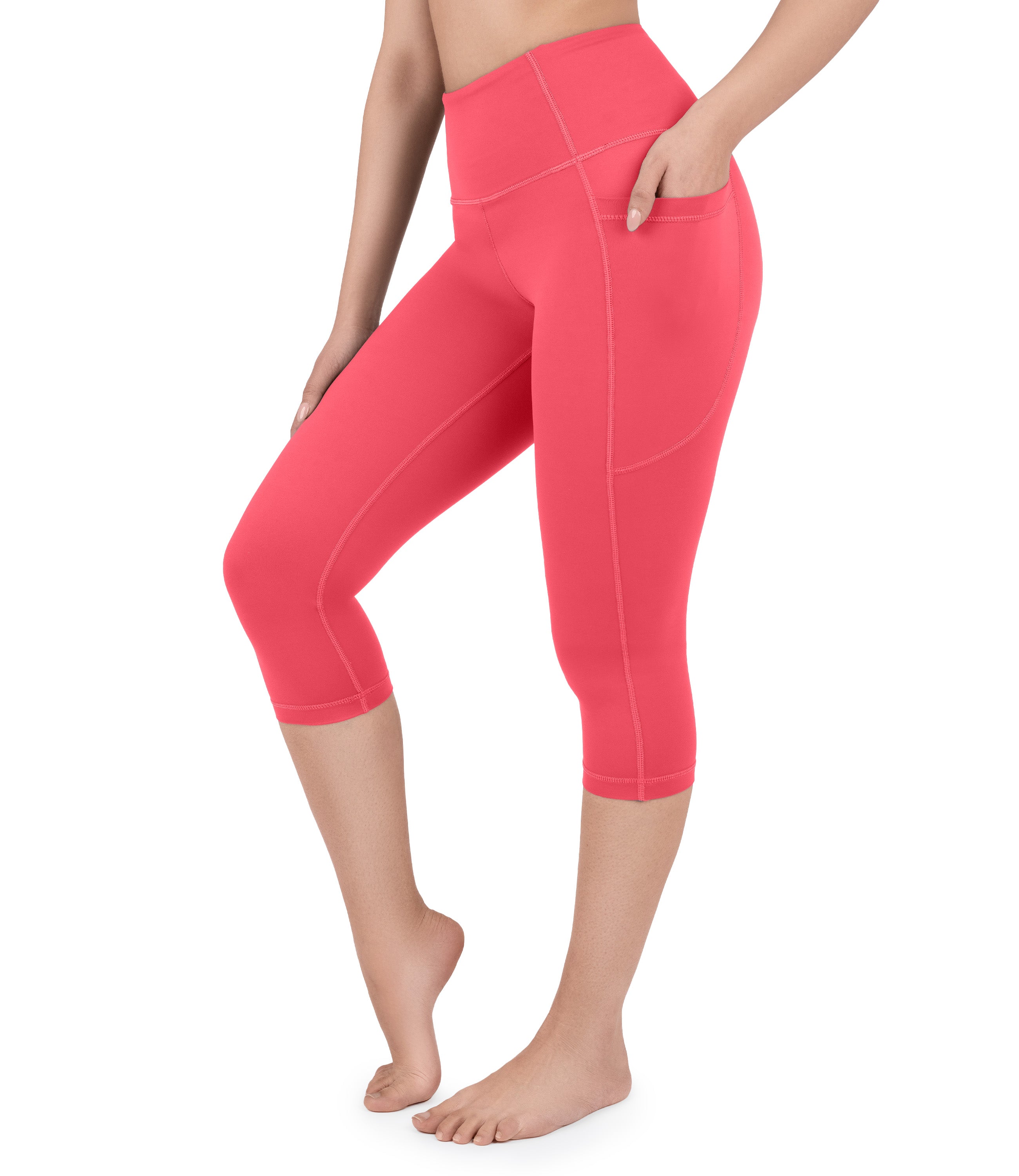 Front view of woman wearing NirLUX capri leggings with pockets in viva magenta