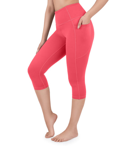 Front view of woman wearing NirLUX capri leggings with pockets in viva magenta